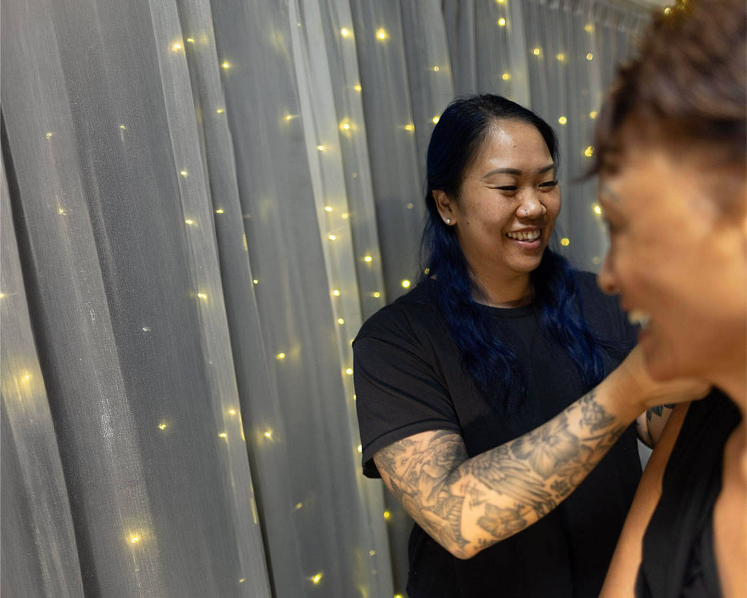 Jackie putting ear seed on a client