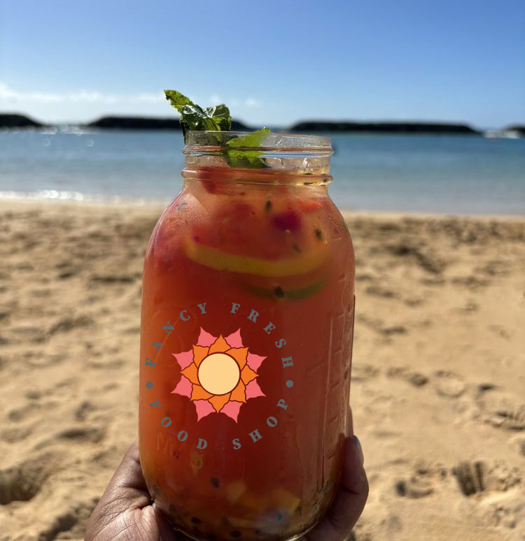 Fancy Fresh Juice Shop logo on a jar of juice at the beach